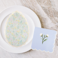 In Bloom Paper Napkins styled with matching floral tableware and pastel accents.