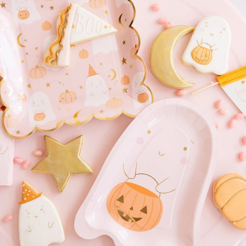 Close-up of pink square Halloween paper plates adorned with cute ghost and pumpkin illustrations, part of a pink Halloween decor collection from a Halloween party kit.