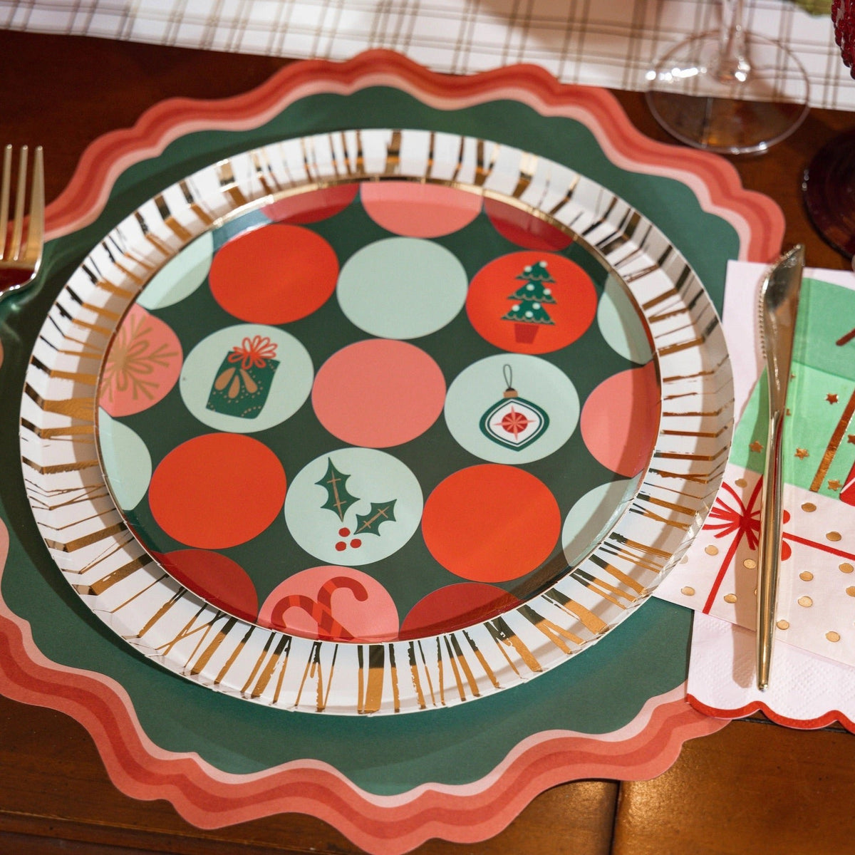 Christmas-themed table setting with a white and gold foil dinner paper plate, surrounded by festive decor. These 10.5-inch gold paper plates are perfect for Christmas dinner, holiday gatherings, and elegant dining events.