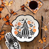 Halloween party setup with witch plates, hand-shaped napkins, and floral orange napkins from the Halloween party kit. Ideal for a party in a box.