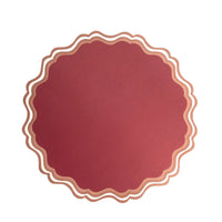 Maroon paper placemat with scalloped edges.