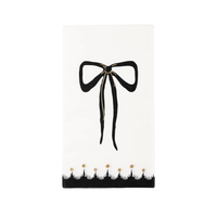 a paper dinner napkin with black and gold designs featuring a bow