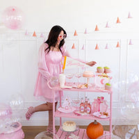 6-foot Halloween garland with 12 pink and gold witch hats, featuring glittery brims and gold foil stars, hung against a white wall.