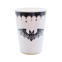 a paper cup with black and gold designs featuring a black lace bat perfect for halloween.