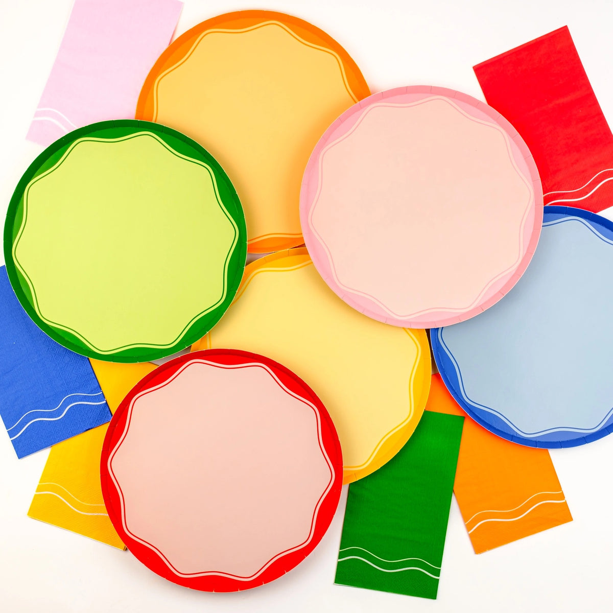 Bright and colorful napkins arranged under matching plates, ideal for adding a pop of color to any event. These paper guest towels are perfect as rainbow-themed or decorative paper napkins