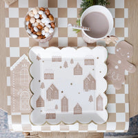 A tan and white Checkered paper table runner on a Christmas table setting