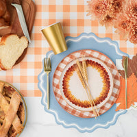 Brown and white watercolor plaid paper plate with matching feather plate and pumpkin charger plate on a Thanksgiving table setting.