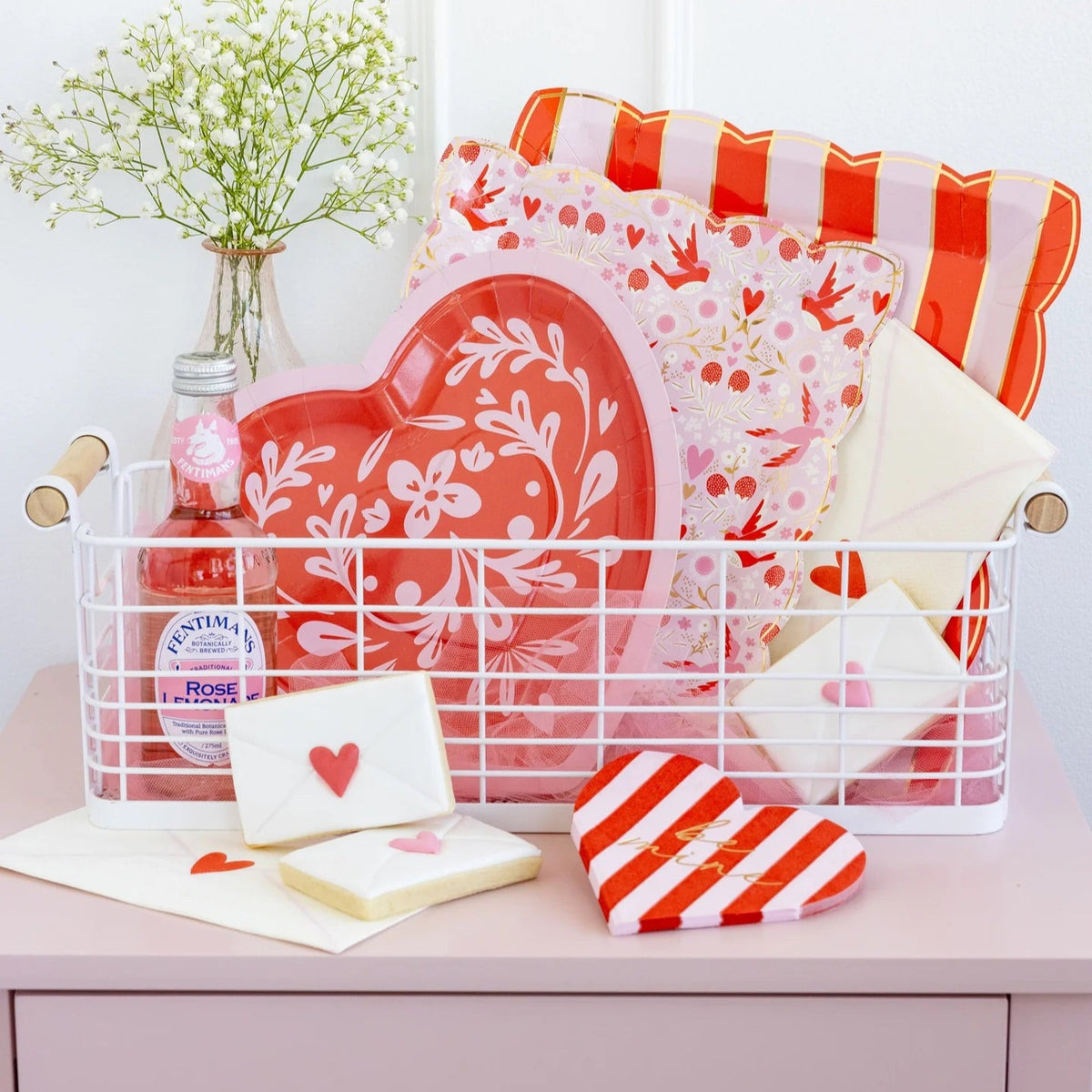 White Napkin Shaped like an envelope with a red heart stamp with coordinating valentines day party decorations