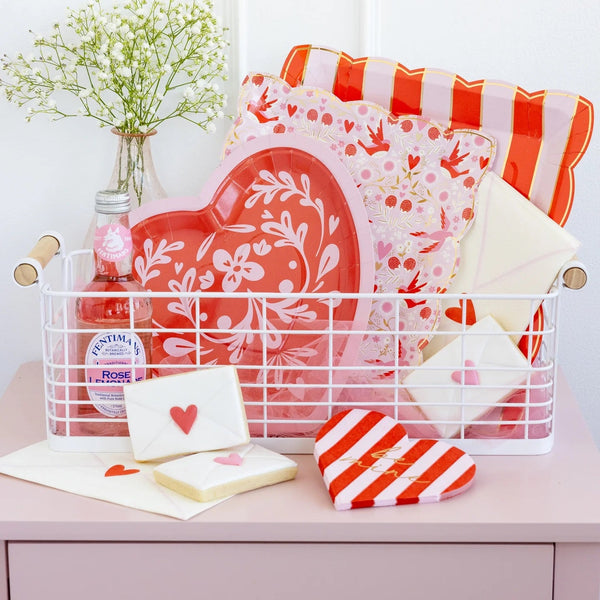 Valentine plates with lovebird patterns set on a decorated table featuring pink and red party decor.