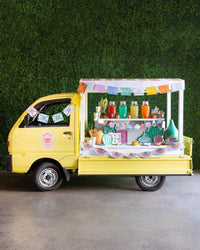 Festive bar cart with a Papel Picado Banner, margaritas, and fresh limes.