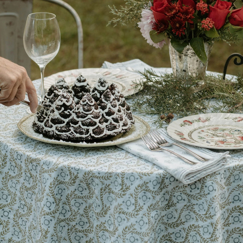 A sage green tablecloth with a floral print perfect for Easter and Spring