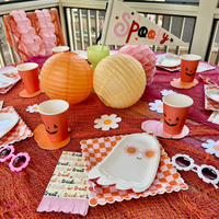 A Halloween party table setting featuring 'Trick or Treat' themed Halloween napkins, paired with a playful ghost plate and other Halloween party decor.