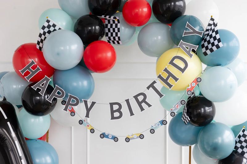 Miles Per Hour Happy Birthday Banner set up as a backdrop for a little boy’s car-themed birthday party.