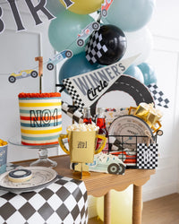 Miles Per Hour Trophy Treat Cups placed alongside car-themed decorations at a Two Fast Birthday celebration.