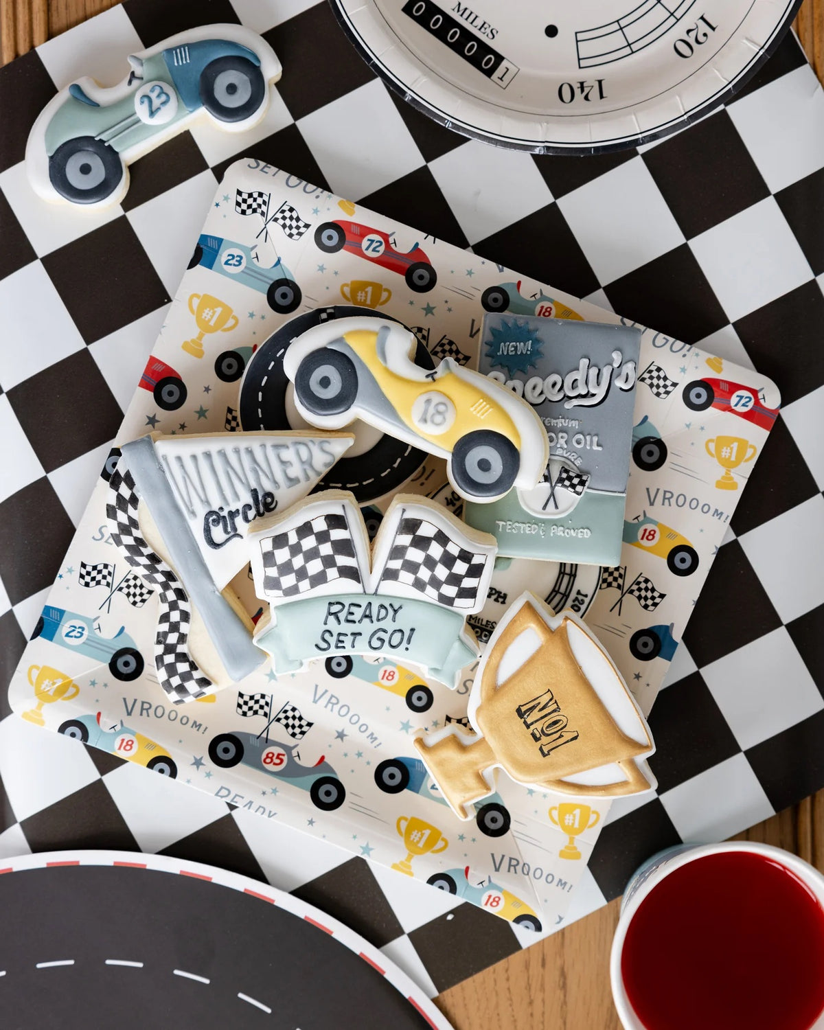 Stylish Miles Per Hour Race Pattern Plates decorating the dining table at a Two Fast Birthday race car-themed party.