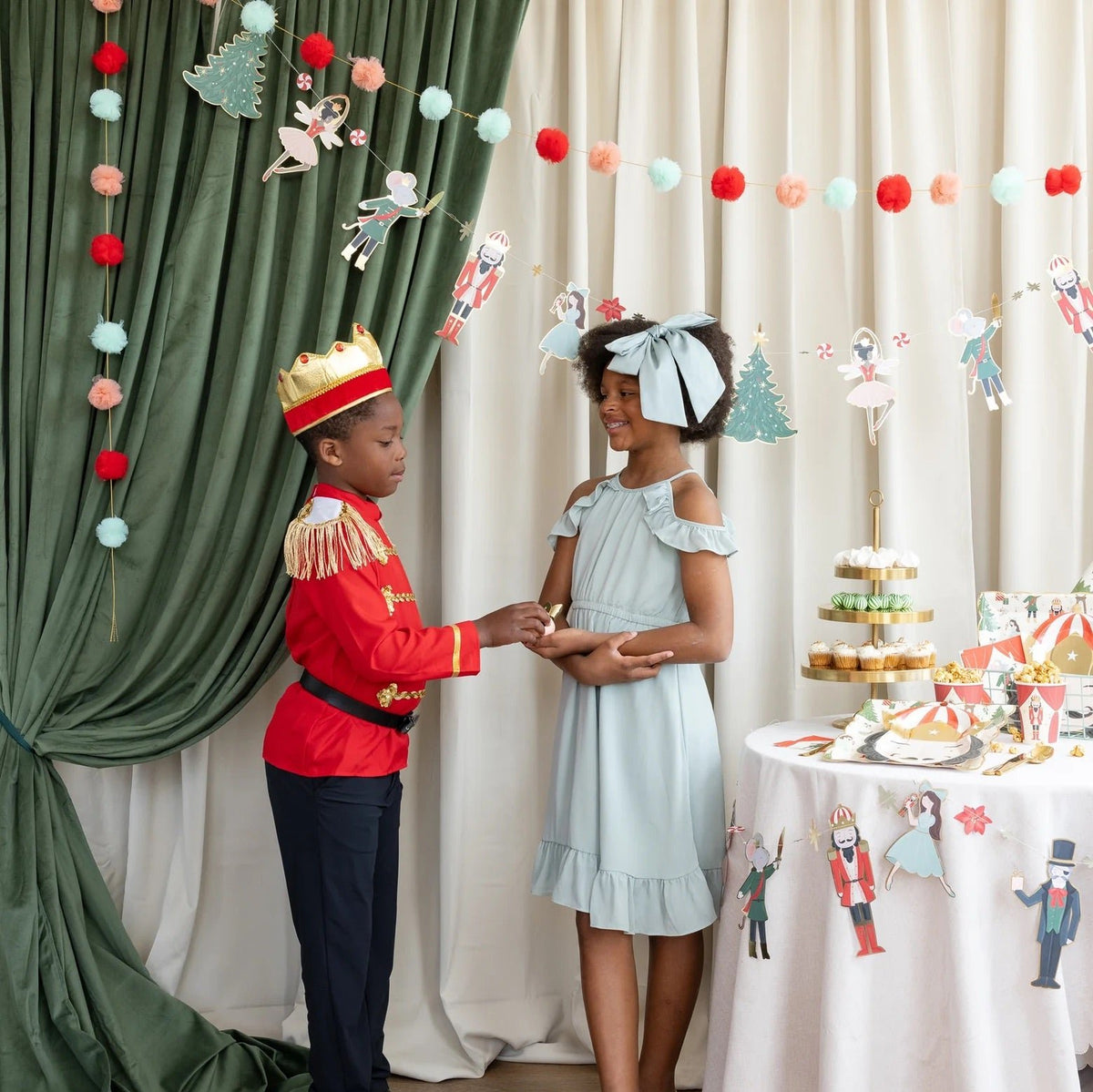 Little kids in front of the The Nutcracker Party Banner