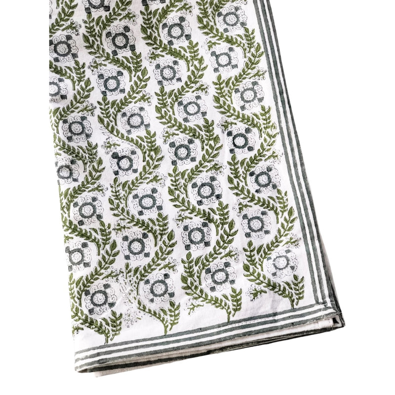 A sage green tablecloth with a floral print perfect for Easter and Spring