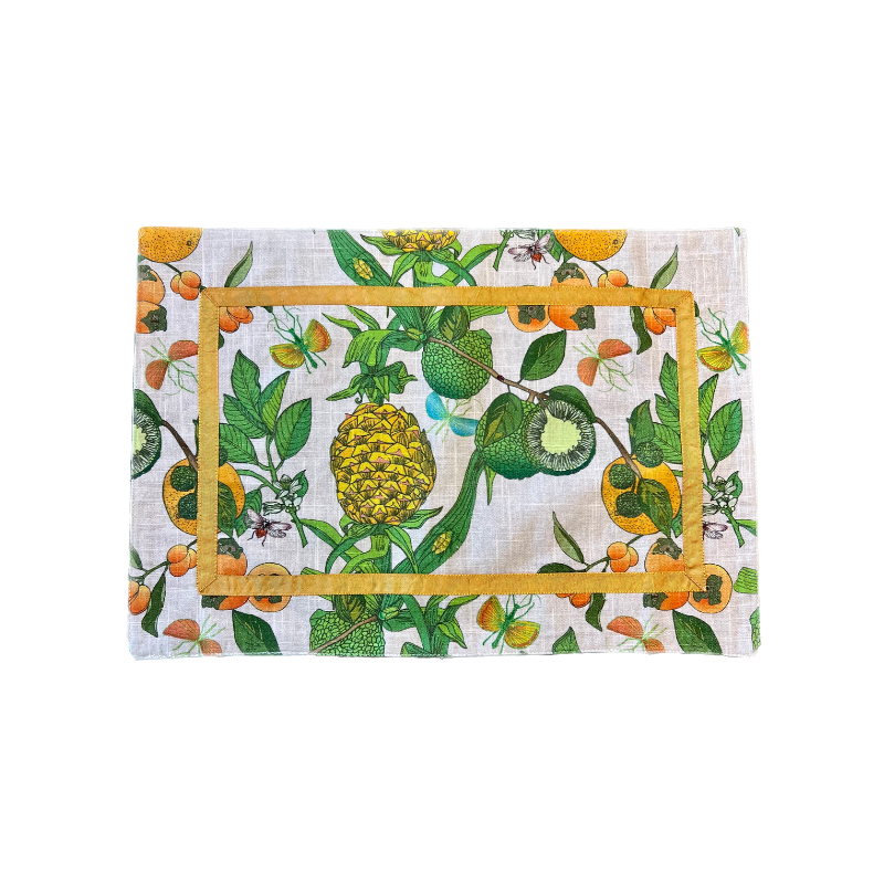 Transform your table setting with our Pineapple Garden Enameled Rectangle Placemats. This set of four summer placemats, crafted from textured 100% cotton, features a delightful design of pineapples, limes, and oranges, accented with an orange ribbon trim. They're not just placemats—they're a statement piece and an excellent choice for a hostess gift or personal treat.