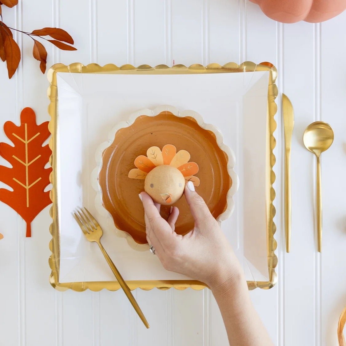 A Thanksgiving place setting featuring a turkey surprise ball, ideal for engaging Thanksgiving activities for kids at the Thanksgiving kids table.