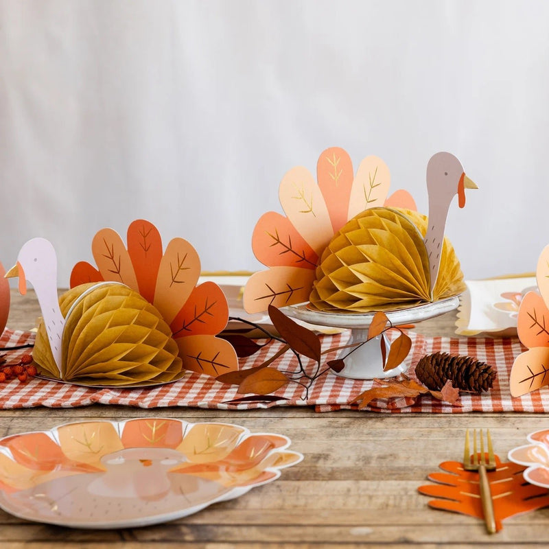 A charming honeycomb turkey centerpiece with brown tissue paper body and colorful tail feathers in shades of orange and cream, ideal for a Thanksgiving kids' table or as a fun Thanksgiving centerpiece.