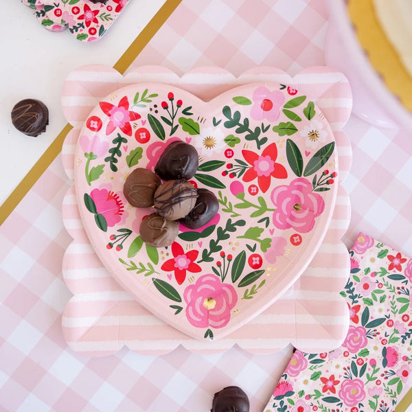 Tonal striped Valentine plates styled on a festive table with coordinating pink and red party decor.