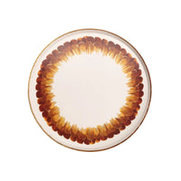 A white paper dessert plate with brown and gold feather design perfect for a fall or Thanksgiving party.