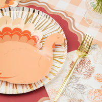 Maroon paper placemat with scalloped edges paired with a turkey shaped paper plate.