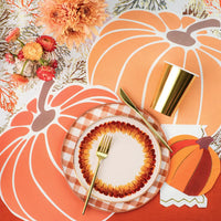 Paper pumpkin placemats on a Thanksgiving table setting. 