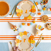 A paper cup with a turkey face design, complete with colorful feathers attached, perfect for a Thanksgiving kids table and ideal for serving festive drinks like apple cider or hot cocoa.