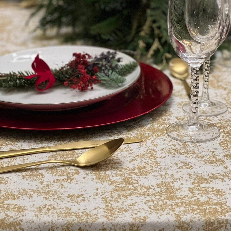 Gold and White tablecloth on a Christmas table setting.