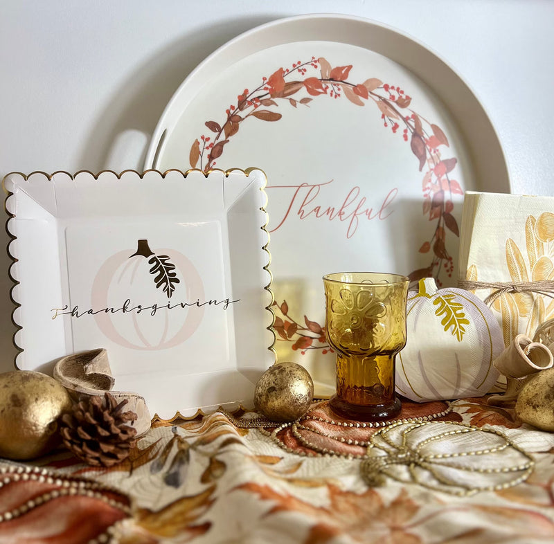 Thanksgiving paper plates featuring a gold foil edge and a pumpkin.
