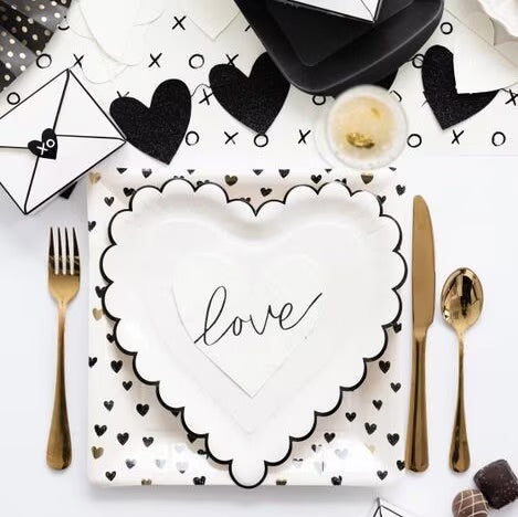 White heart-shaped napkins with black cursive love across the napkin - perfect for an anniversary party, a bridal shower or valentines day